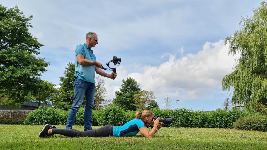 2 B Seen Photo & Video - over ons Een man houdt een camera vast terwijl een vrouw op de grond foto's maakt.
